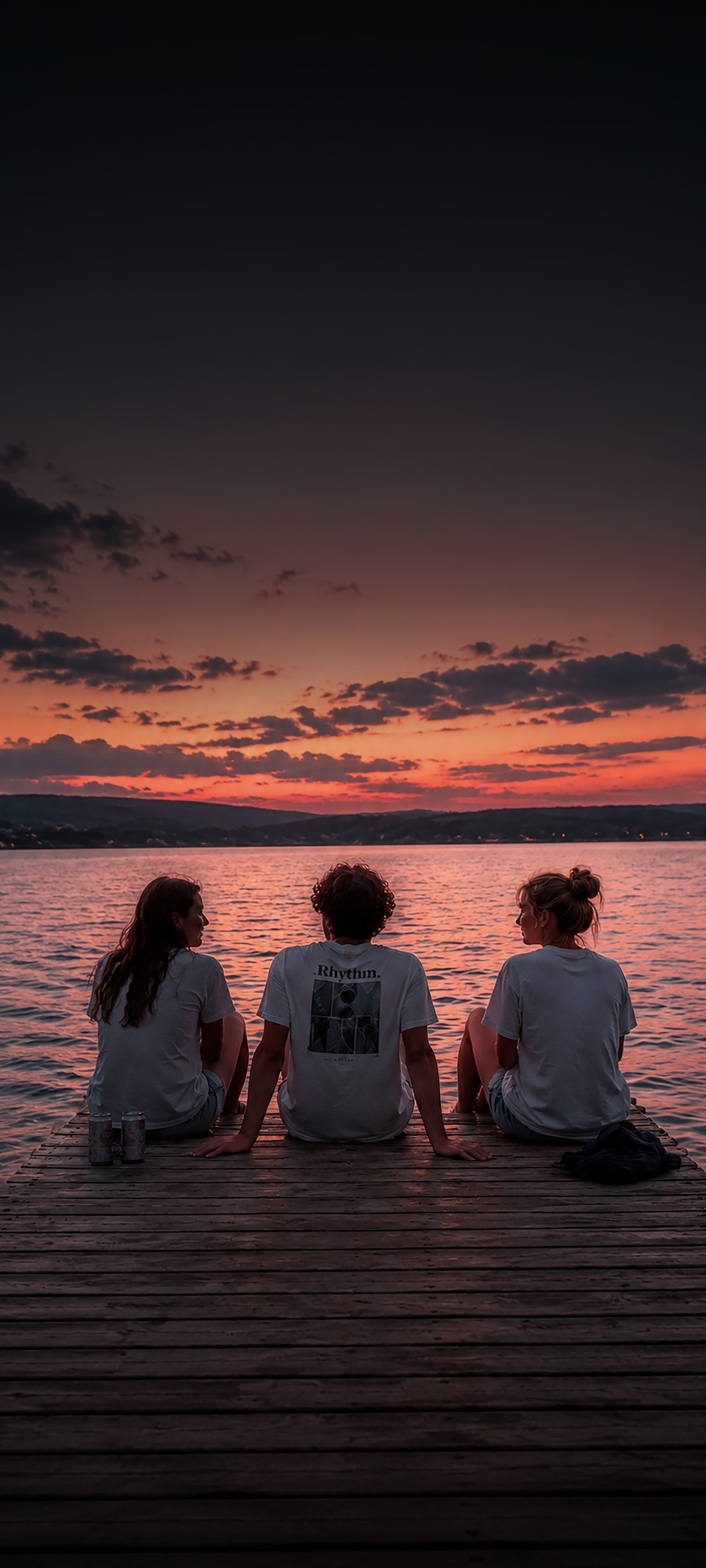 Friends sharing a sunset by a lake